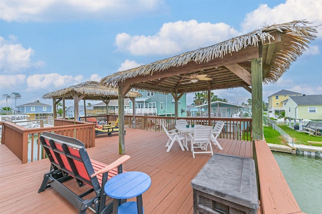 wooden terrace with a gazebo, outdoor dining space, and a residential view
