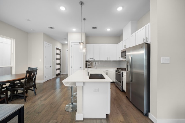 kitchen with white cabinets, appliances with stainless steel finishes, a sink, and visible vents
