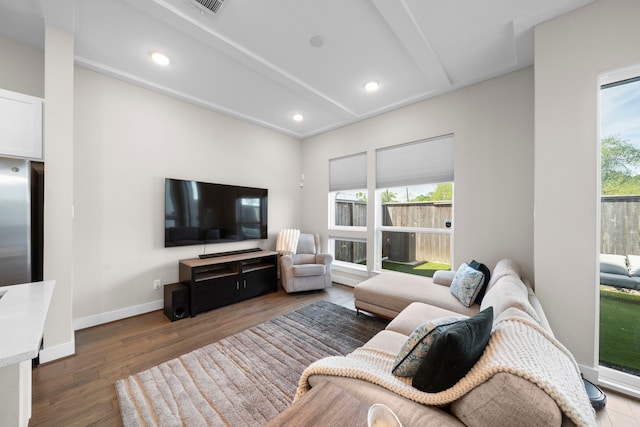living area featuring wood finished floors, vaulted ceiling with beams, baseboards, visible vents, and recessed lighting