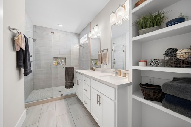 bathroom featuring a sink, double vanity, a stall shower, recessed lighting, and tile patterned flooring