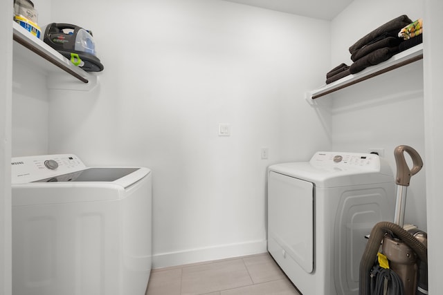 laundry room with light tile patterned floors, baseboards, laundry area, and independent washer and dryer