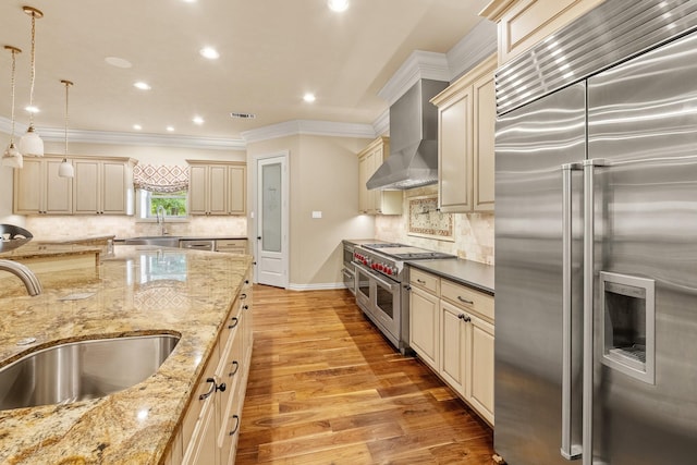 28002 Whispering Maple Way, Spring, TX 77386 - kitchen with high quality appliances, cream cabinetry, a sink, crown molding, and wall chimney range hood