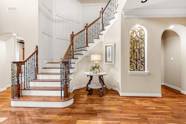 28002 Whispering Maple Way, Spring, TX 77386 - stairs with arched walkways, wood finished floors, baseboards, crown molding, and a high ceiling