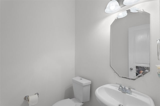 half bath featuring toilet and a sink