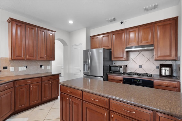 kitchen featuring arched walkways, visible vents, appliances with stainless steel finishes, and under cabinet range hood