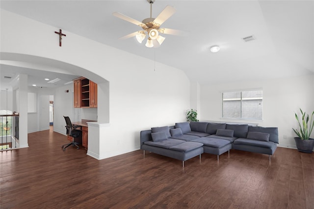 living area with arched walkways, ceiling fan, baseboards, and dark wood-style flooring