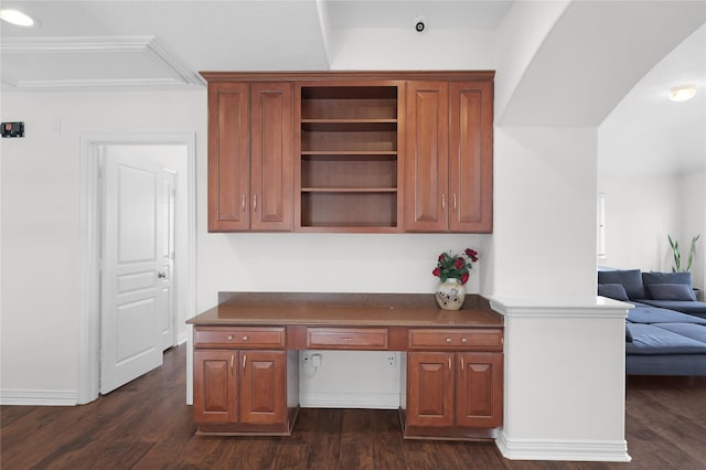 unfurnished office with built in study area, dark wood finished floors, and baseboards