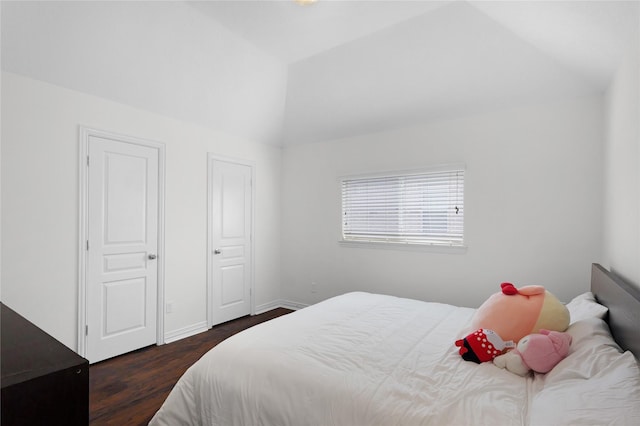 bedroom featuring lofted ceiling, wood finished floors, and baseboards