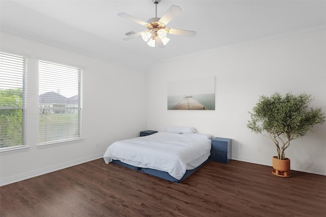 bedroom with baseboards, crown molding, wood finished floors, and visible vents