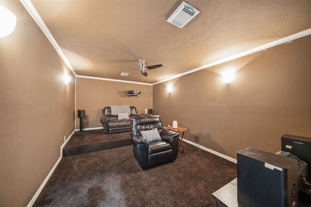 carpeted home theater with baseboards, a ceiling fan, visible vents, and crown molding