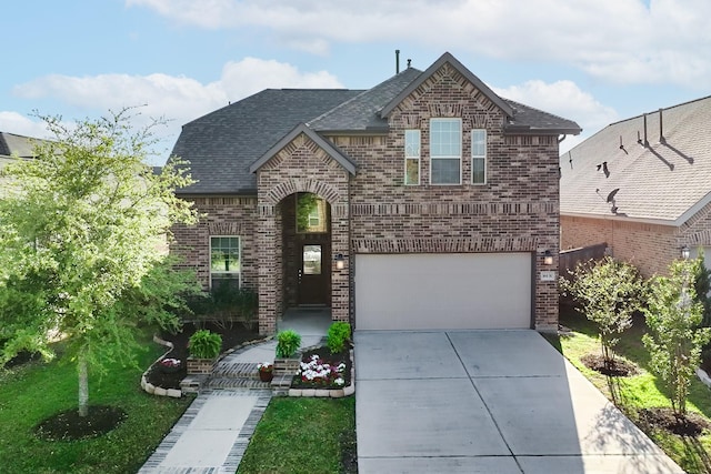 view of front of house with an attached garage, brick siding, roof with shingles, and concrete driveway