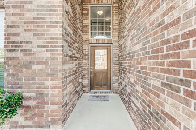 doorway to property featuring brick siding
