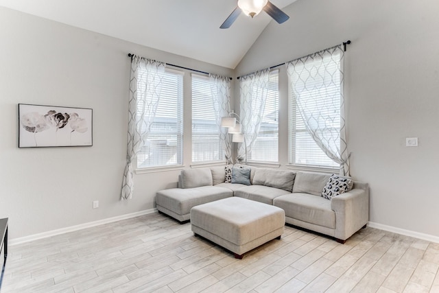 living room with vaulted ceiling, a ceiling fan, light wood finished floors, and baseboards