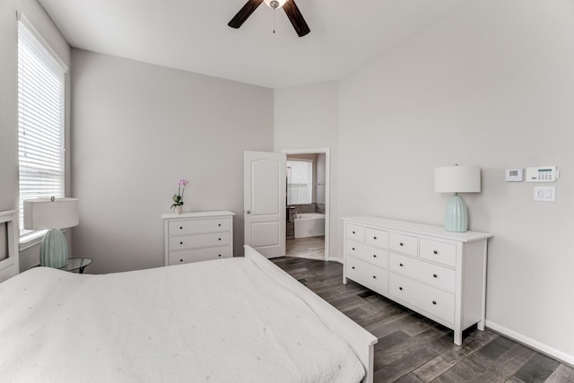 bedroom featuring ensuite bath, baseboards, ceiling fan, and dark wood finished floors