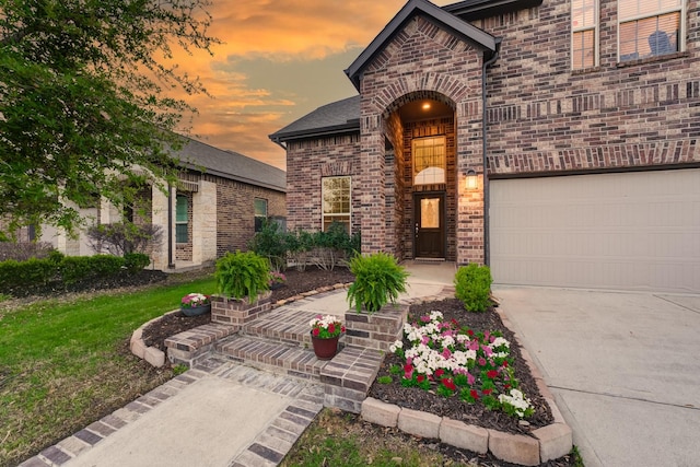 view of front of house with a front lawn, driveway, brick siding, and a garage