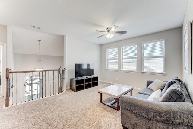 carpeted living room featuring visible vents, a ceiling fan, and baseboards