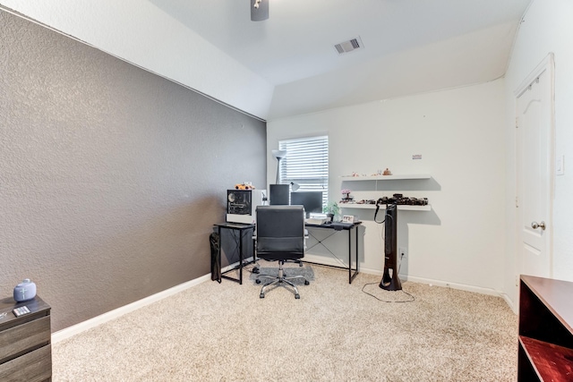 carpeted office space with lofted ceiling, baseboards, visible vents, and a textured wall