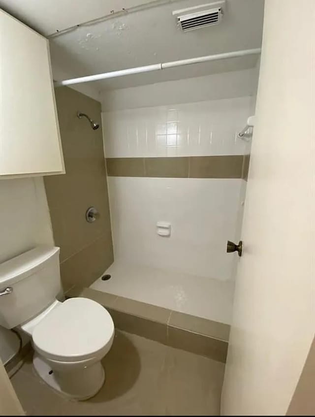 bathroom with visible vents, toilet, and a stall shower