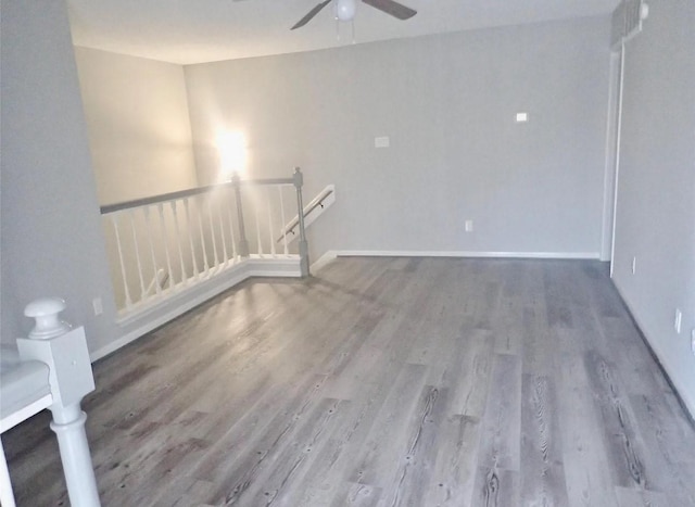 interior space featuring baseboards, a ceiling fan, and wood finished floors