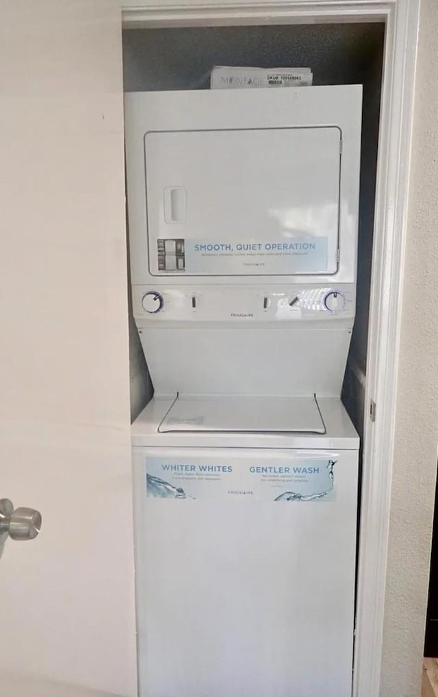 laundry room featuring stacked washer / drying machine and laundry area