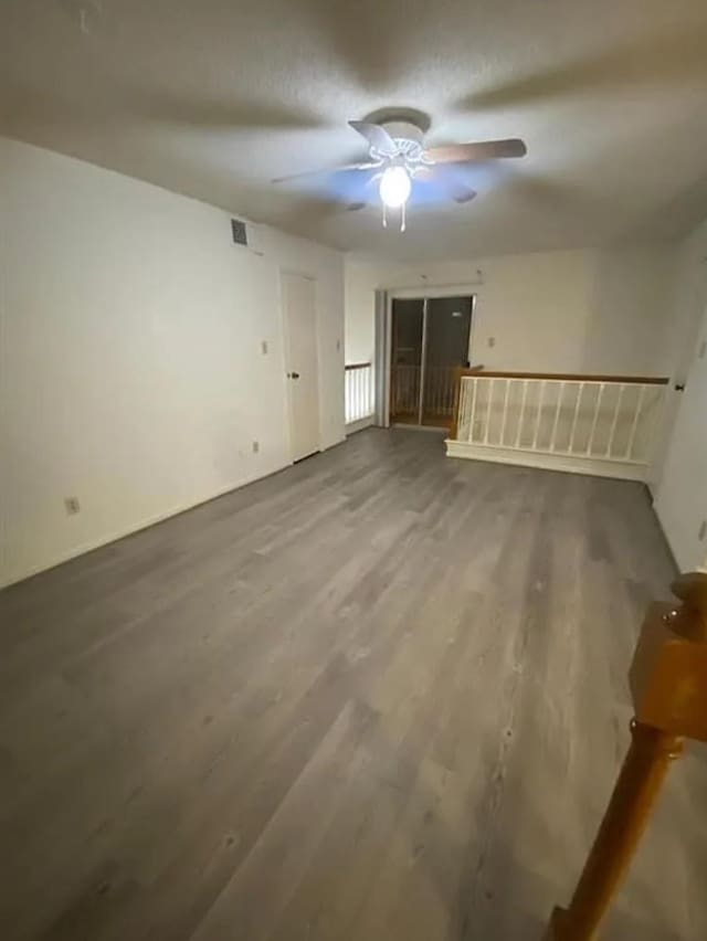 unfurnished room featuring visible vents, wood finished floors, and ceiling fan