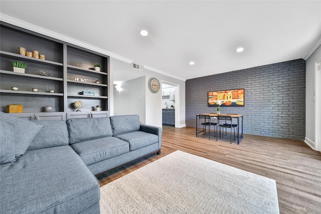 818 Wax Myrtle Ln, Houston, TX 77079 - living area with wood finished floors, visible vents, baseboards, and brick wall