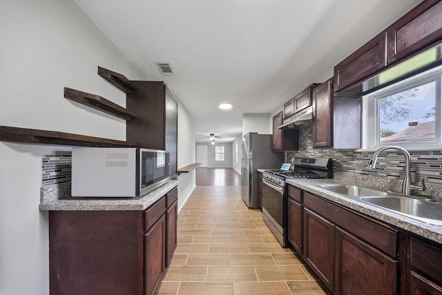504 Stimpson St, Baytown, TX 77520 - kitchen featuring a sink, visible vents, backsplash, under cabinet range hood, and appliances with stainless steel finishes