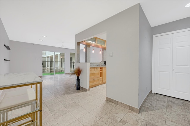 interior space featuring baseboards, recessed lighting, marble finish floor, and a sink