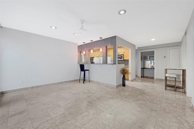 unfurnished living room featuring a ceiling fan, baseboards, and recessed lighting