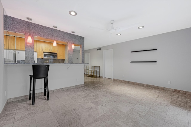 kitchen featuring recessed lighting, a kitchen breakfast bar, visible vents, stainless steel microwave, and a peninsula