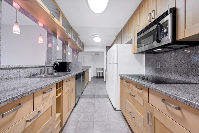 kitchen with light stone counters, tasteful backsplash, stainless steel appliances, and a sink