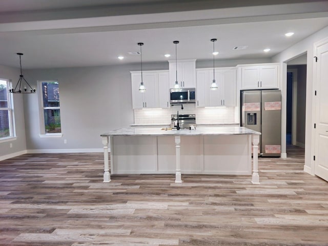20 Lazy Spgs, Trinity, TX 75862 - kitchen with tasteful backsplash, light wood-style floors, stainless steel appliances, white cabinets, and baseboards