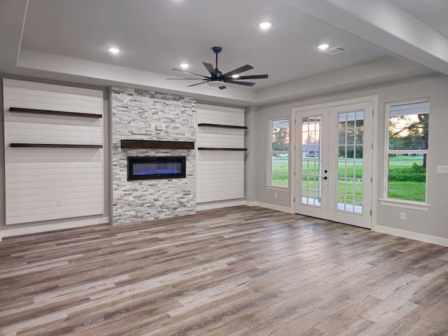20 Lazy Spgs, Trinity, TX 75862 - unfurnished living room with wood finished floors, ceiling fan, visible vents, a raised ceiling, and french doors