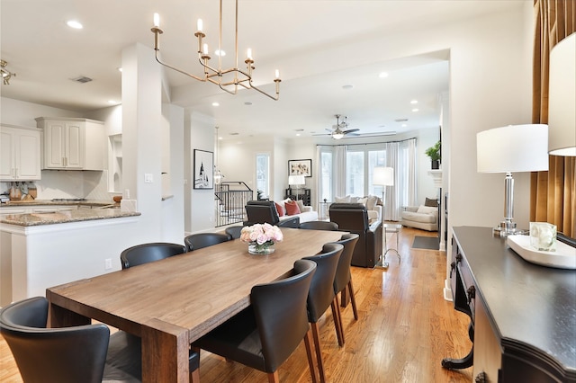 dining area with recessed lighting, visible vents, ceiling fan with notable chandelier, and light wood-type flooring