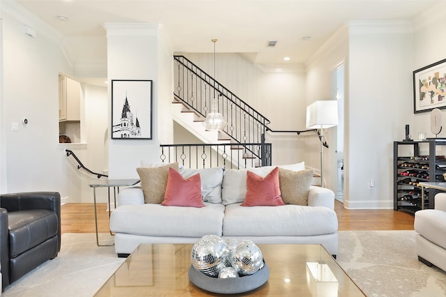 living area featuring visible vents, ornamental molding, stairs, wood finished floors, and baseboards