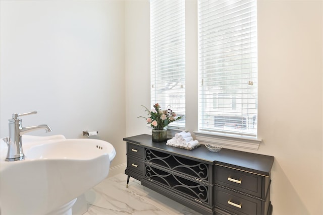 bathroom with a sink and marble finish floor