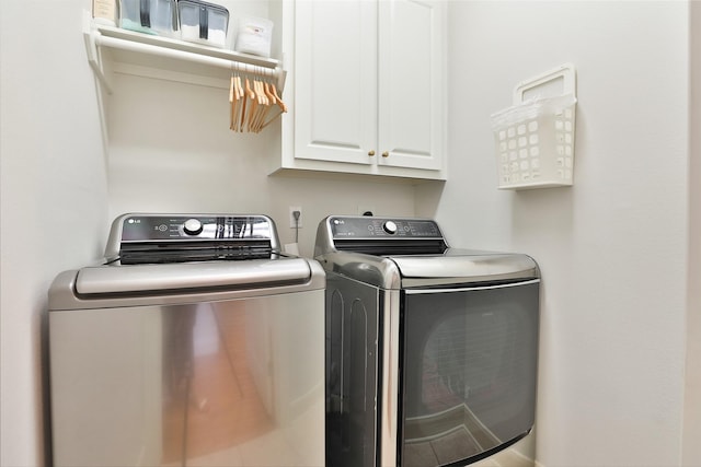 laundry area featuring washer and clothes dryer and cabinet space