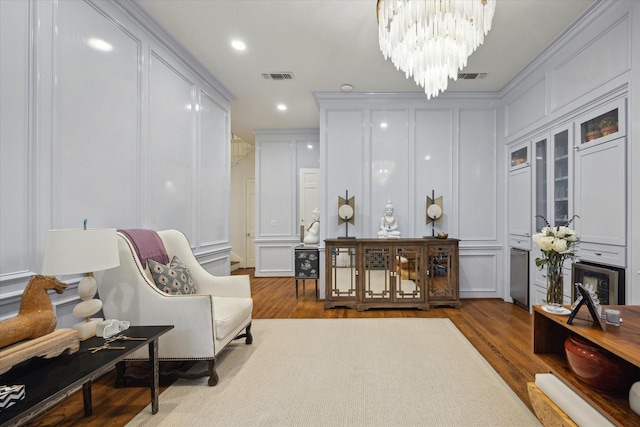 living area with visible vents, recessed lighting, a chandelier, wood finished floors, and a decorative wall