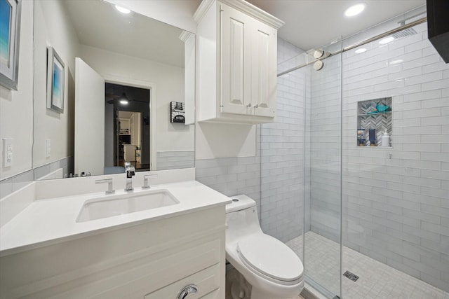 bathroom featuring recessed lighting, a shower stall, toilet, vanity, and tile walls