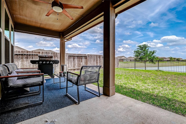 view of patio / terrace with a ceiling fan, area for grilling, a fenced backyard, and a water view