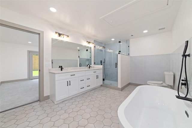 11931 S Red Cedar Cir, The Woodlands, TX 77380 - full bath with a freestanding tub, double vanity, a stall shower, recessed lighting, and toilet