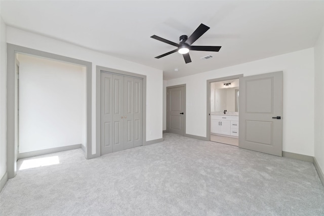 11931 S Red Cedar Cir, The Woodlands, TX 77380 - unfurnished bedroom with light carpet, baseboards, a ceiling fan, connected bathroom, and a closet