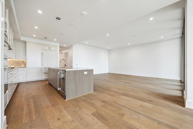kitchen with visible vents, a center island with sink, dishwasher, light wood-style floors, and recessed lighting