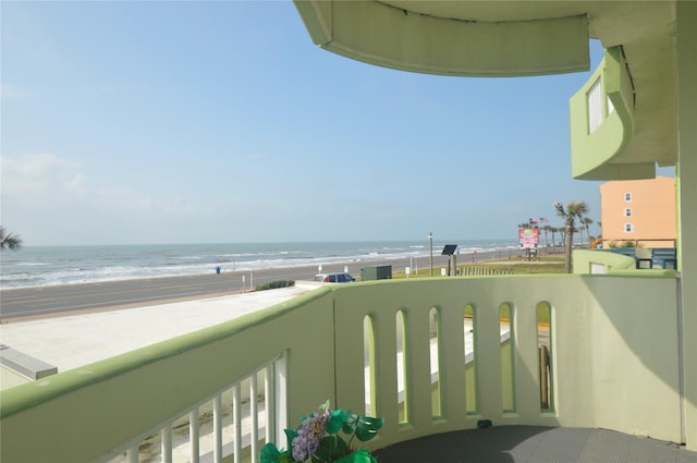 balcony featuring a beach view and a water view
