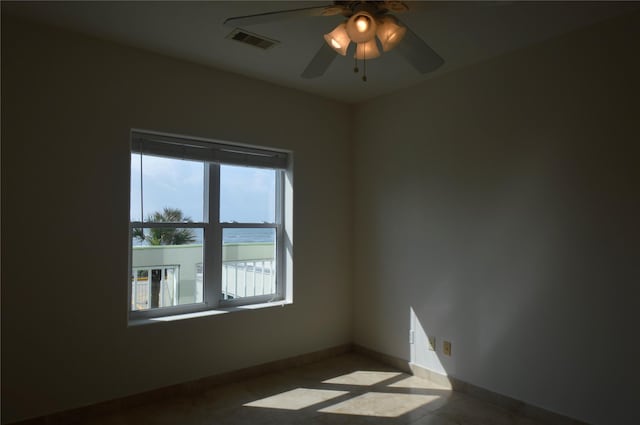 unfurnished room featuring baseboards, a ceiling fan, and visible vents