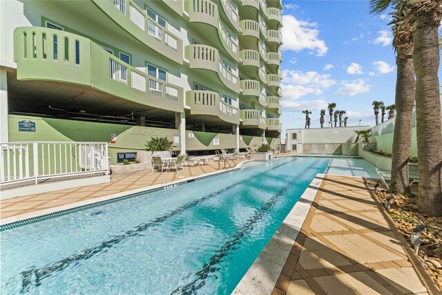 community pool featuring fence and a patio area