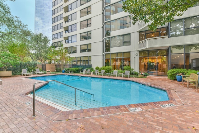 pool with a patio area and fence