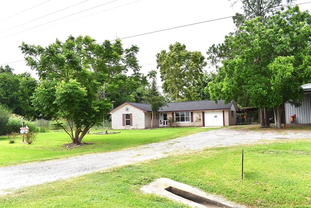 12112 Fm-457, Cedar Lane, TX 77415 - ranch-style house featuring gravel driveway, a front yard, brick siding, and an attached garage
