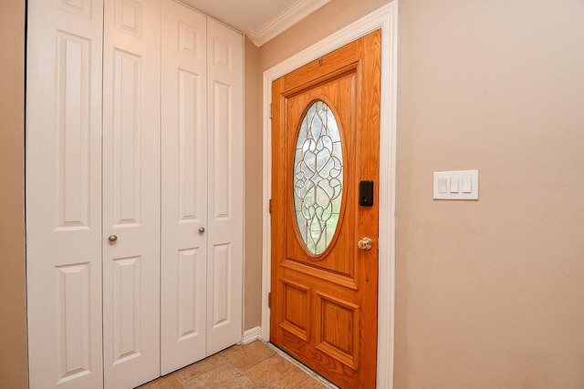 foyer with baseboards and crown molding