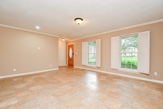 spare room with stone finish flooring, baseboards, and ornamental molding